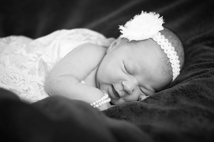 Potret monoton yang manis dari seorang bayi perempuan - fotografi bayi baru lahir