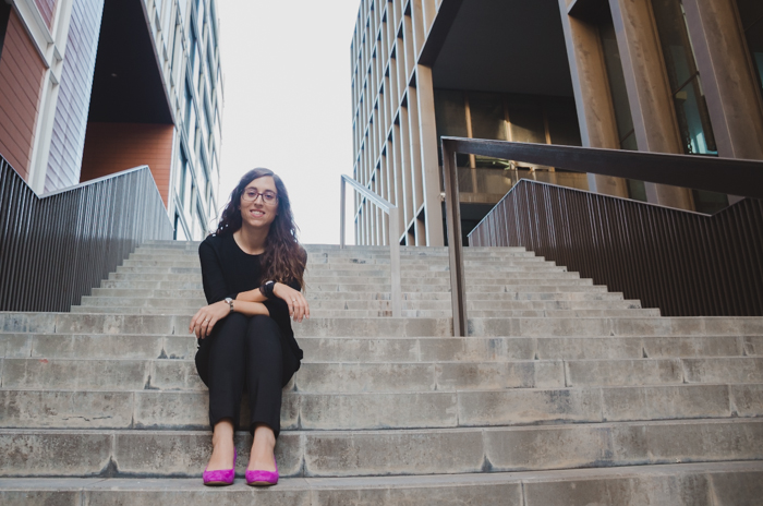 žena model v růžové boty sedí na kamenných schodech
