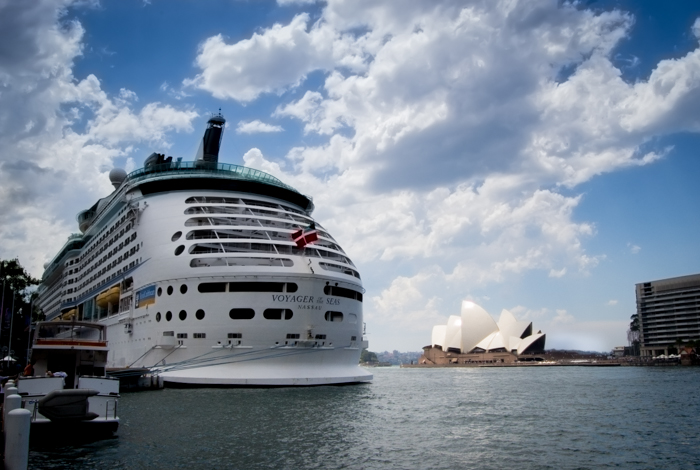 Uma grande balsa ancorada no porto, com a opera house de Sydney atrás