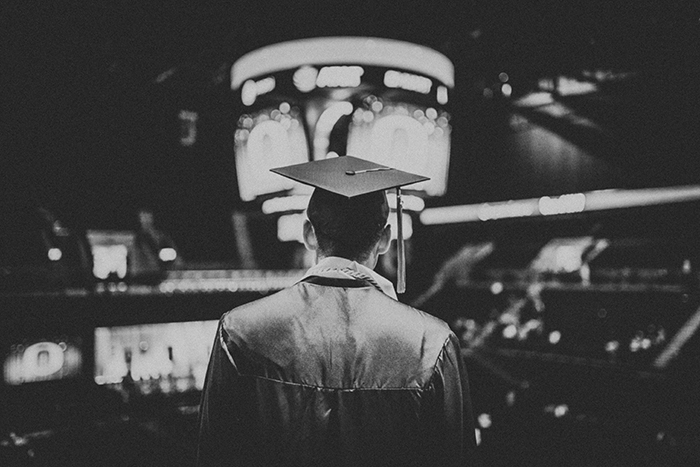 Candid monotone graduation portrait of a male student indoors