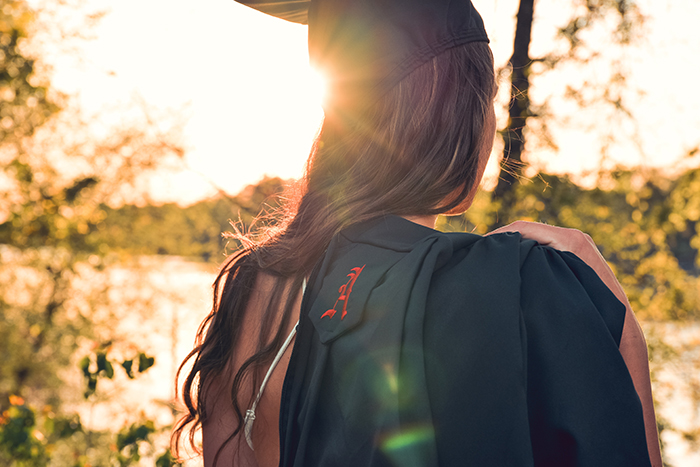 森の中の屋外で女子学生の美しい率直な卒業ポートレート