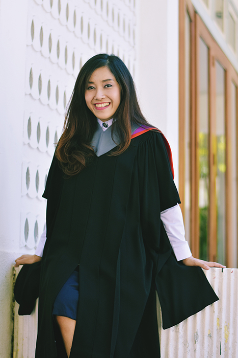 Beau portrait de remise de diplômes d'une étudiante posant en extérieur