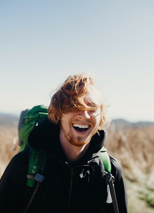Un excursionista masculino sonriente: cómo sonreír para las fotos
