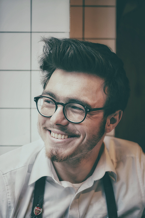 Egy szemüveges férfi portréja, aki természetesen mosolyog