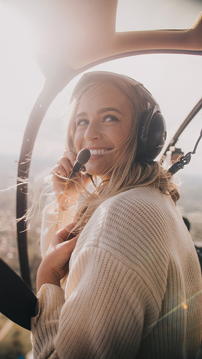 Et glædesfyldt foto af en blond kvinde i et fly, der smiler naturligt