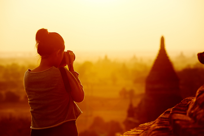 dreamy portrait of a woman taking architecture photographer at sunset