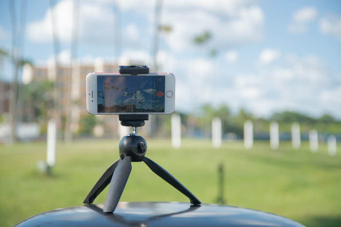 um telefone em um tripé ao ar livre para tirar fotos com lapso de tempo do iphone