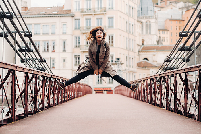 Mädchen springt auf eine symmetrische Brücke.