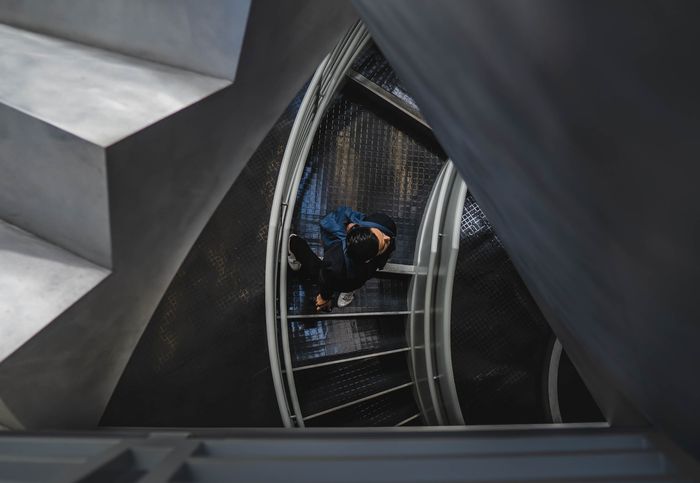 Photo d'un gars montant sur un escalier en colimaçon