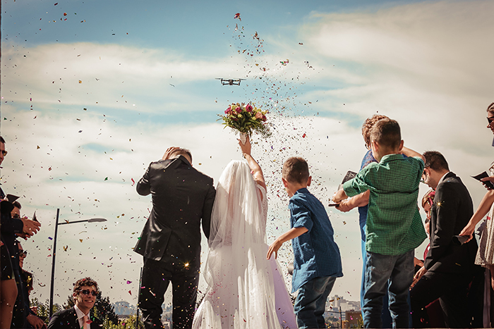 Foto pernikahan pasangan yang sudah menikah dan kelopak bunga di udara