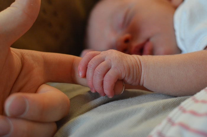 Fotografi bayi baru lahir DIY yang memegang jari orang tua