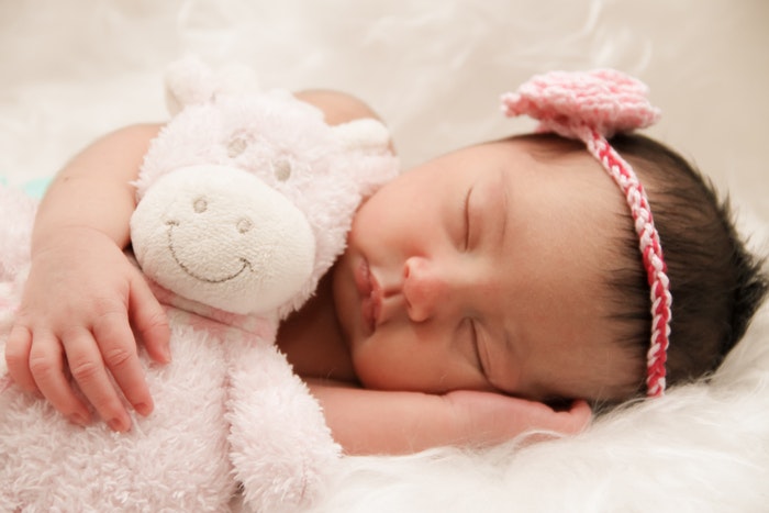 DIY newborn photography of baby sleeping with toy