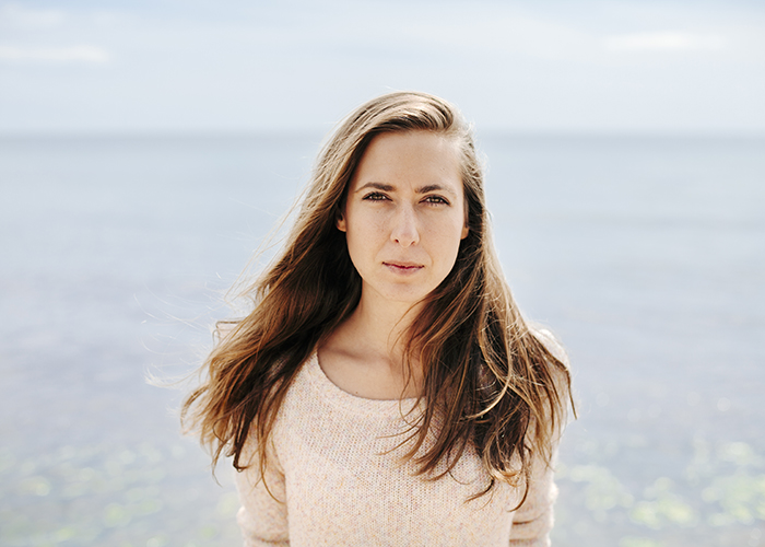 portret van een jonge vrouw op het strand.