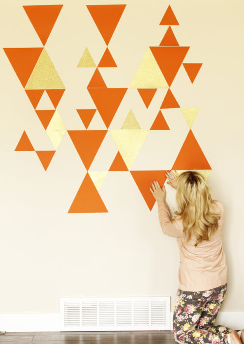 Une femme créant un motif mural géométrique