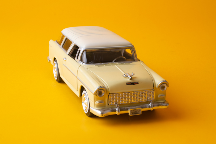 Uma imagem nítida de um carro de brinquedo em um fundo amarelo