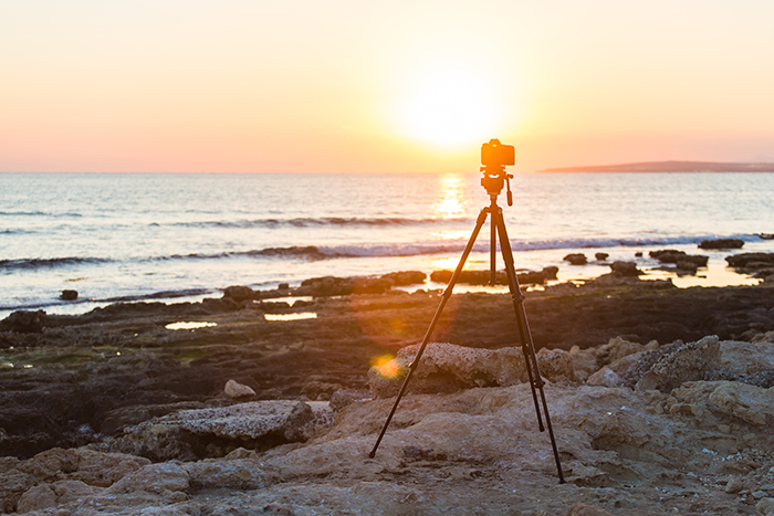 Camera with tripod over sunset near blue hour.