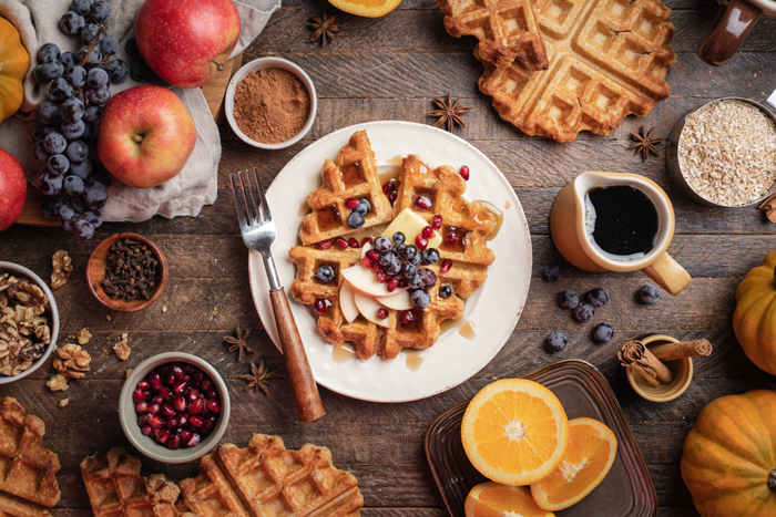 Foto aérea de waffles e frutas em uma mesa rústica