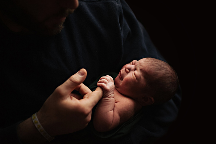 Seorang bayi yang baru lahir digendong oleh ayahnya