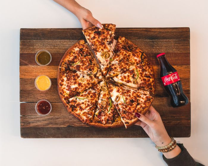 Foto aérea de mãos tomando fatias de pizza