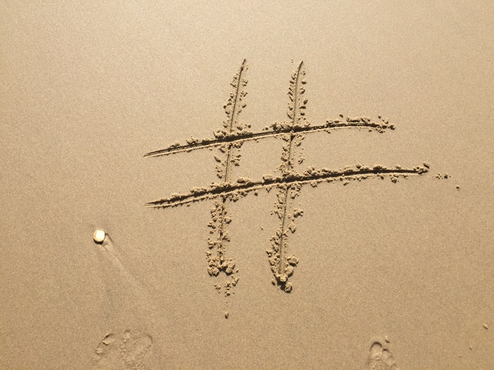 en hashtag trukket i sandet