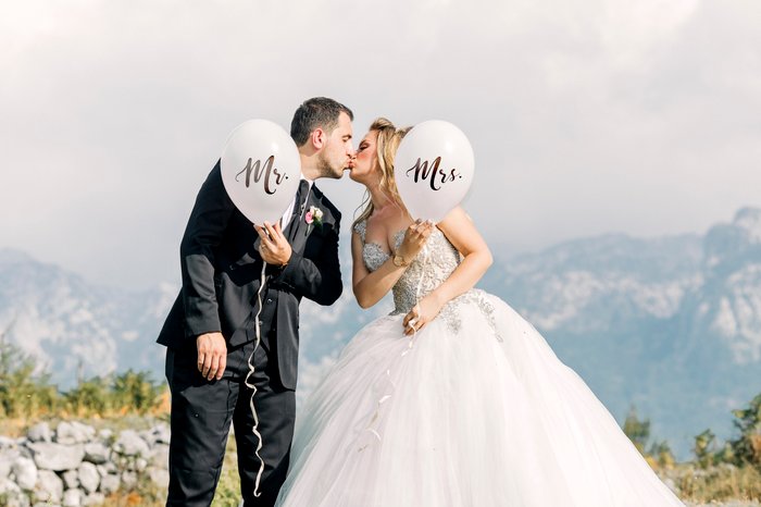 Retrato de casamento bonito da noiva e do noivo posando com balões