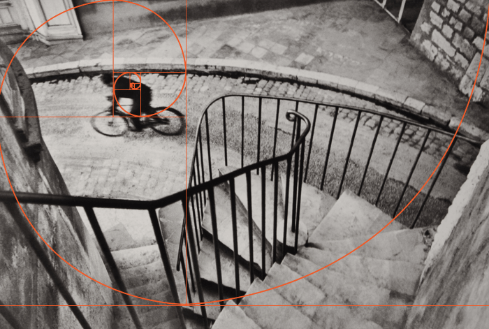 um henri cartier bresson preto e branco de um ciclista fotografado de cima com uma sobreposição espiral de fibonacci
