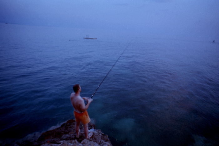 Foto de filme expirada de um homem pescando