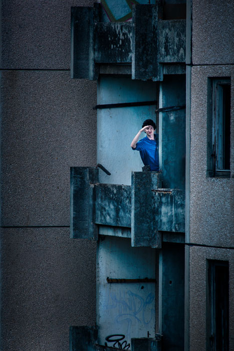 Uma pessoa em pé na varanda de um apartamento. 
