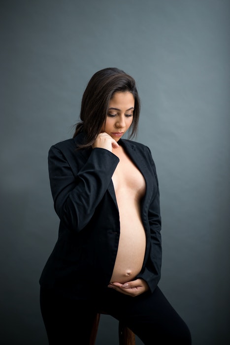 Linda foto de maternidade de uma grávida posando em um estúdio