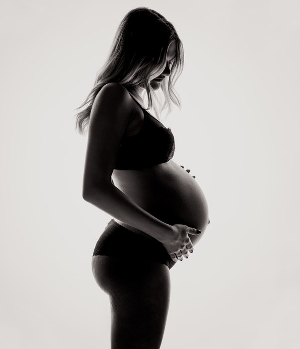 Linda foto de maternidade de uma grávida posando de lingerie