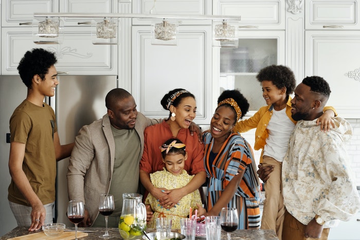 Uma grande família posando em uma cozinha 