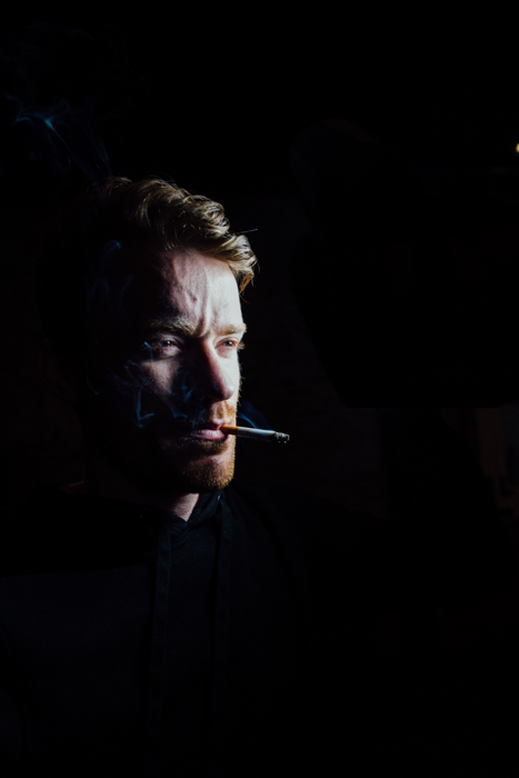 Potret studio gelap seorang pria dengan latar belakang hitam