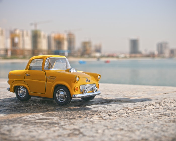 Um carro de táxi amarelo de brinquedo na parede
