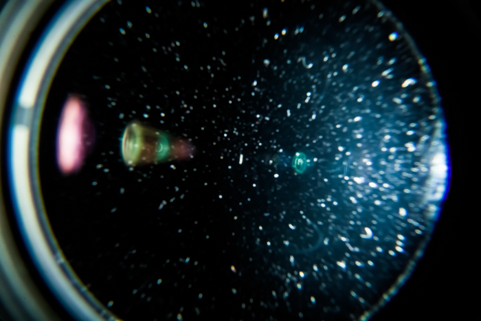 Close-up da lente da câmera com partículas de poeira ou fungo na lente 
