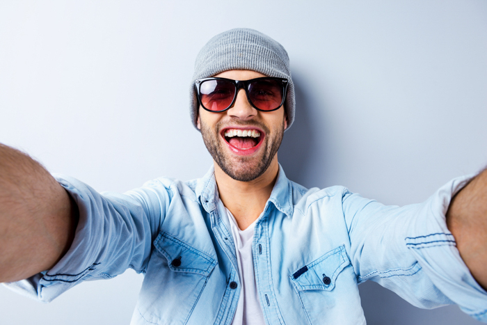 um homem de óculos escuros demonstra uma das melhores poses para selfies