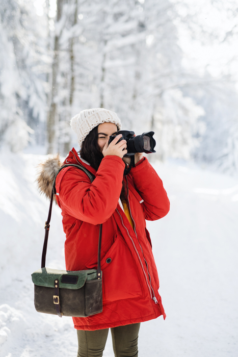 Um fotógrafo tirando fotos de inverno ao ar livre.