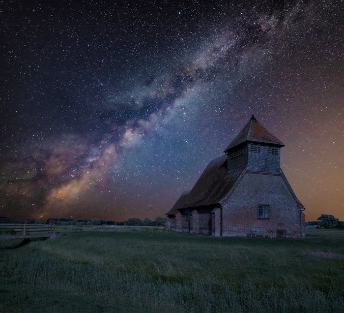 Imagem da Via Láctea atrás de uma paisagem com um edifício antigo