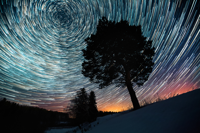 Uma imagem de astrofotografia de longa exposição de trilhas de estrelas.