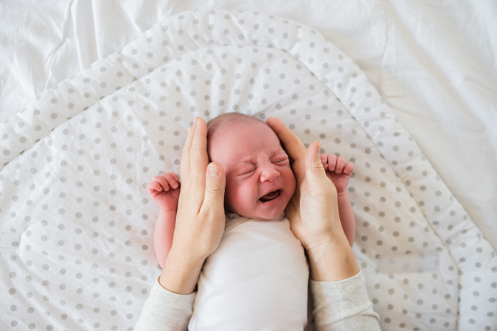 Doce retrato de um bebê recém-nascido sendo segurado por um pai
