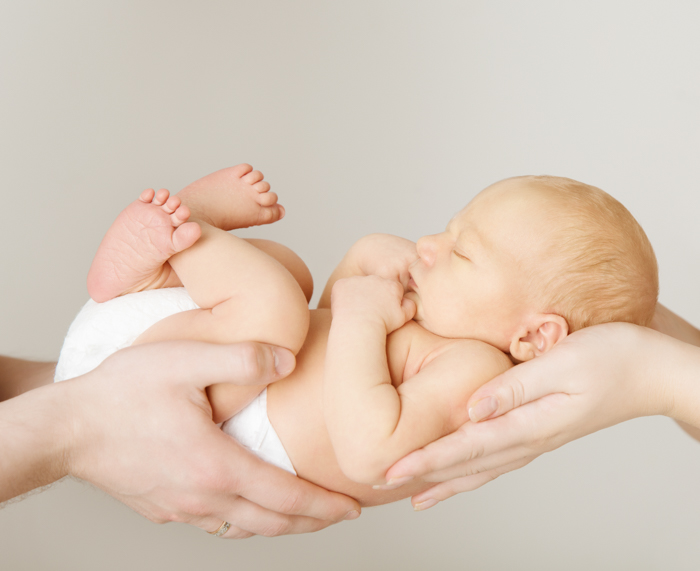 Doce ideia para a foto de um bebê recém-nascido descansando nas mãos dos pais