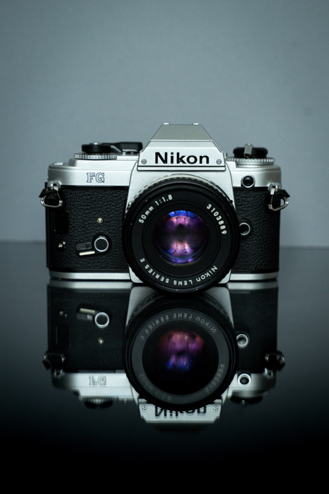 Kamera Nikon SLR pada permukaan reflektif