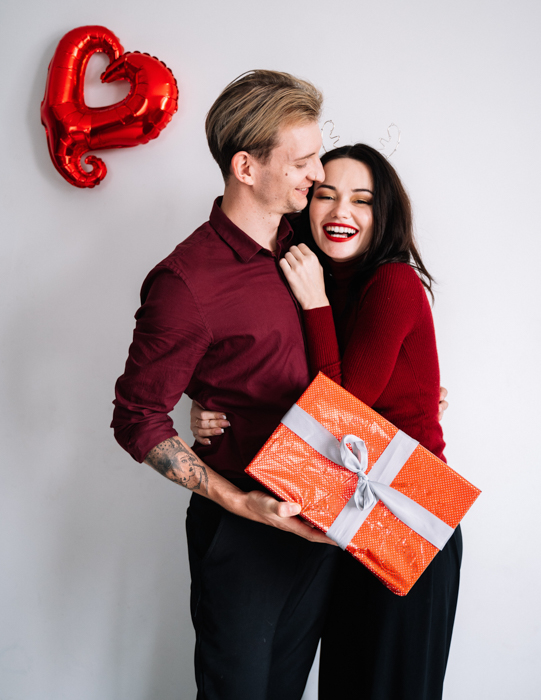 Gambar pasangan lucu di hari Valentine memegang hadiah