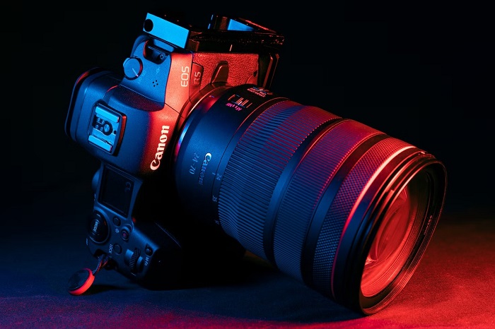 Canon EOS R5 with RF 24-70mm lens attached in red and purple lighting